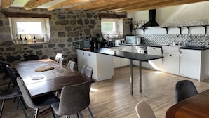 Eine moderne Küche mit Steinwänden, Holzbalken und einer zentralen Kochinsel.