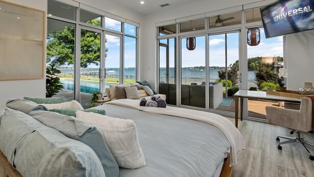 A modern hotel room with a large bed, a desk, and a TV. - Lake Norman Lakefront - Pickleball, Hot Tub, Pool (Mooresville)