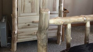 Een houten garderobe met twee deuren en een bankje ervoor.