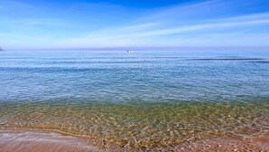 A clear view of a beach with calm water and a distant boat. - CONCHIGLIA 3 minutes from the sea Relax and Holidays - on the Gulf of Castellammare.... (Alcamo)