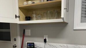 A kitchen with a marble countertop, a digital clock, and a drawer with utensils. - Lake Cottage minutes away from downtown Sparta (Sparta)