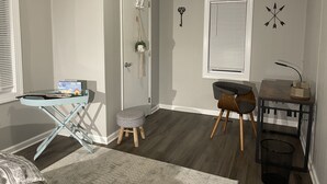 A room with a desk, chair, and a small stool. There is a door with a hanging decoration and a wall-mounted light fixture. - Lake Cottage minutes away from downtown Sparta (Sparta)