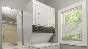 A compact laundry room with a washing machine and dryer, a sink, and a window with blinds. - Lake Cottage minutes away from downtown Sparta (Sparta)