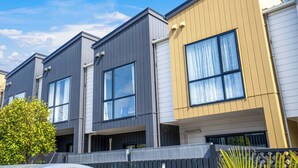 A row of modern townhouses with large windows and a flat roof. - Brand New House by Botany - Parking (Auckland)