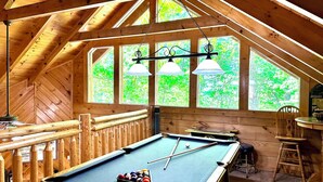 A pool table in a wooden room with large windows and a high ceiling. - Your Perfect Mountain Getaway Cabin in the Heart of Nature (Sevierville)