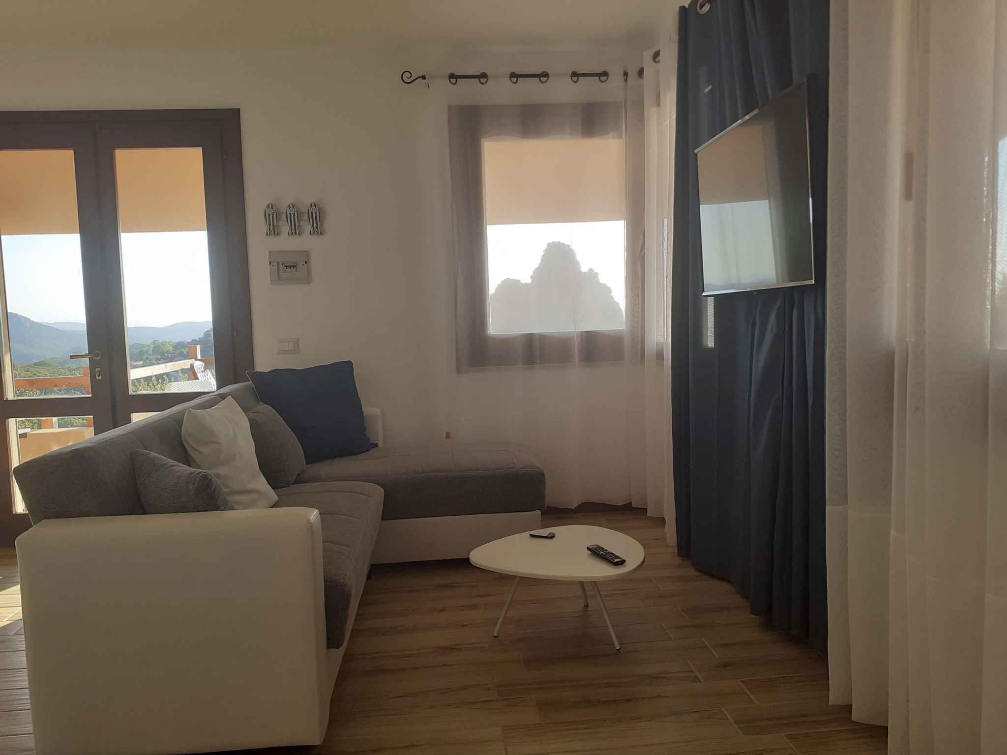 Una sala de estar con un sofá, una mesita redonda y un televisor.