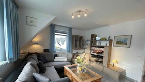 Een moderne woonkamer met een bank, salontafel en een televisie.