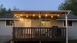 A single-story house with a covered porch, a visible garage door, and a gravel driveway.