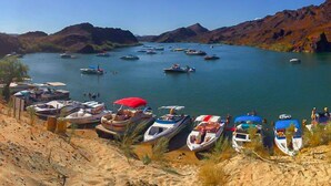 Une zone côtière où des bateaux sont amarrés le long de la rive, offrant une vue dégagée sur les collines environnantes.