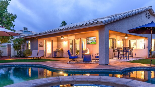 Une maison avec une piscine, un espace extérieur aménagé pour se détendre et une terrasse.