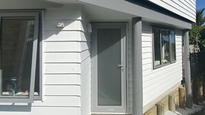 A white building with a garage door, a window, and a door.