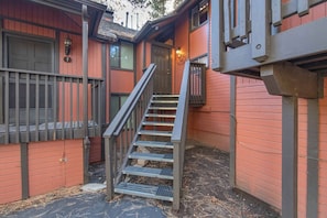A red building with a staircase leading to a door marked with the number 7.
