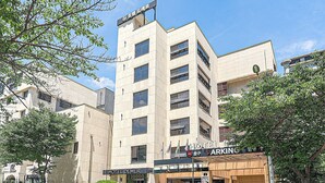 A multi-story hotel building with a sign for 'Hotel Demer' and a parking sign. - Hotel Demer (Mokpo)