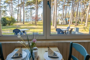 A dining table with a view of a park and a lake.