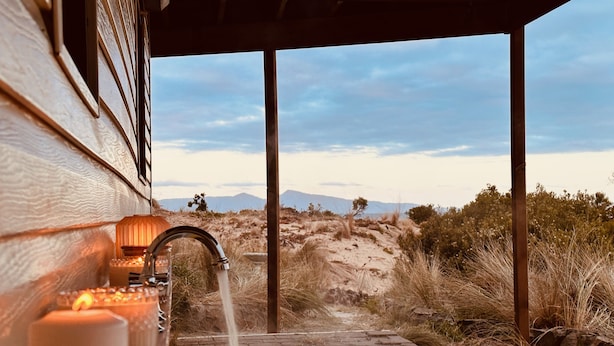 A bathroom with a bathtub, a faucet, and a candle. - Mid-century beach front house, on five private acres, dogs welcome (Dolphin Sands)