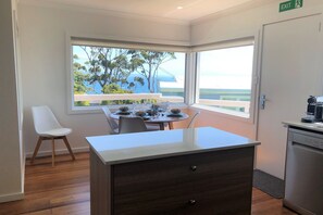 Una cocina moderna con comedor, ventanas amplias y vistas, y una señal de salida.
