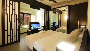 A modern hotel room with a large bed, a television, and a mirror. - Apartment in Hotel Residence (Grand-Baie)