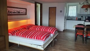 A compact room with a bed, a kitchenette, and a dining area. - Studio for 2-4 Guests With Balcony and Panorama View (Emmetten)