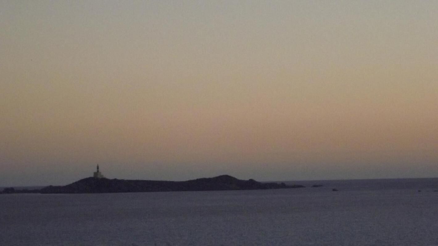 Eine Küstenlandschaft mit einem Leuchtturm auf einer kleinen Insel.