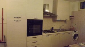 A compact kitchen with a stove, sink, and built-in oven.