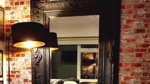 A round glass table with vinyl records, surrounded by white chairs, in a room with exposed brick walls and a large ornate mirror. - 3 Bed House Stunning Views And Free Parking (Brighton)