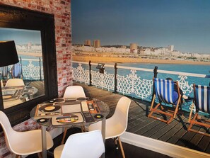 A deck with a DJ setup, white chairs, and a view of the beach and cityscape. - 3 Bed House Stunning Views And Free Parking (Brighton)