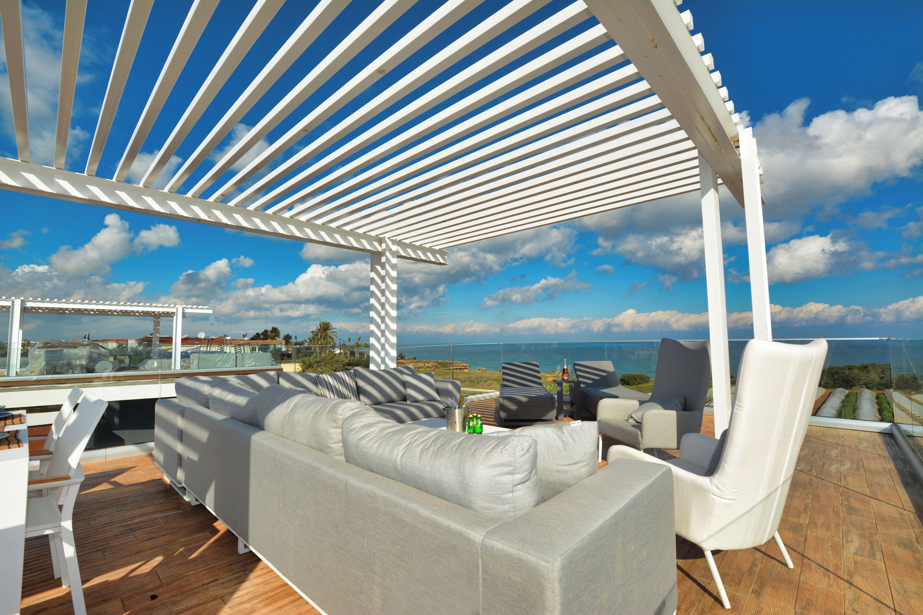 A covered outdoor seating area with a view of the sea.