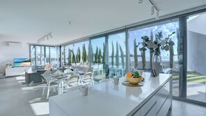 A modern kitchen with a large island, white cabinetry, and a view of the outdoors. - Protaras Holiday Villa Wp8 (Paralimni)