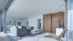 A modern living room with a sofa, coffee table, and a dining area with a table and chairs. - Protaras Holiday Villa Wp8 (Paralimni)