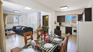 Un appartement moderne comprenant un coin repas, une cuisine, un salon et un escalier menant à l’étage supérieur.