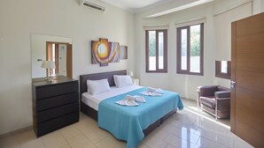 A bedroom with a bed, a dresser, a mirror, a painting, and a window. - Protaras Holiday Villa Pa7 Private 7 Bedroom Villa (Paralimni)