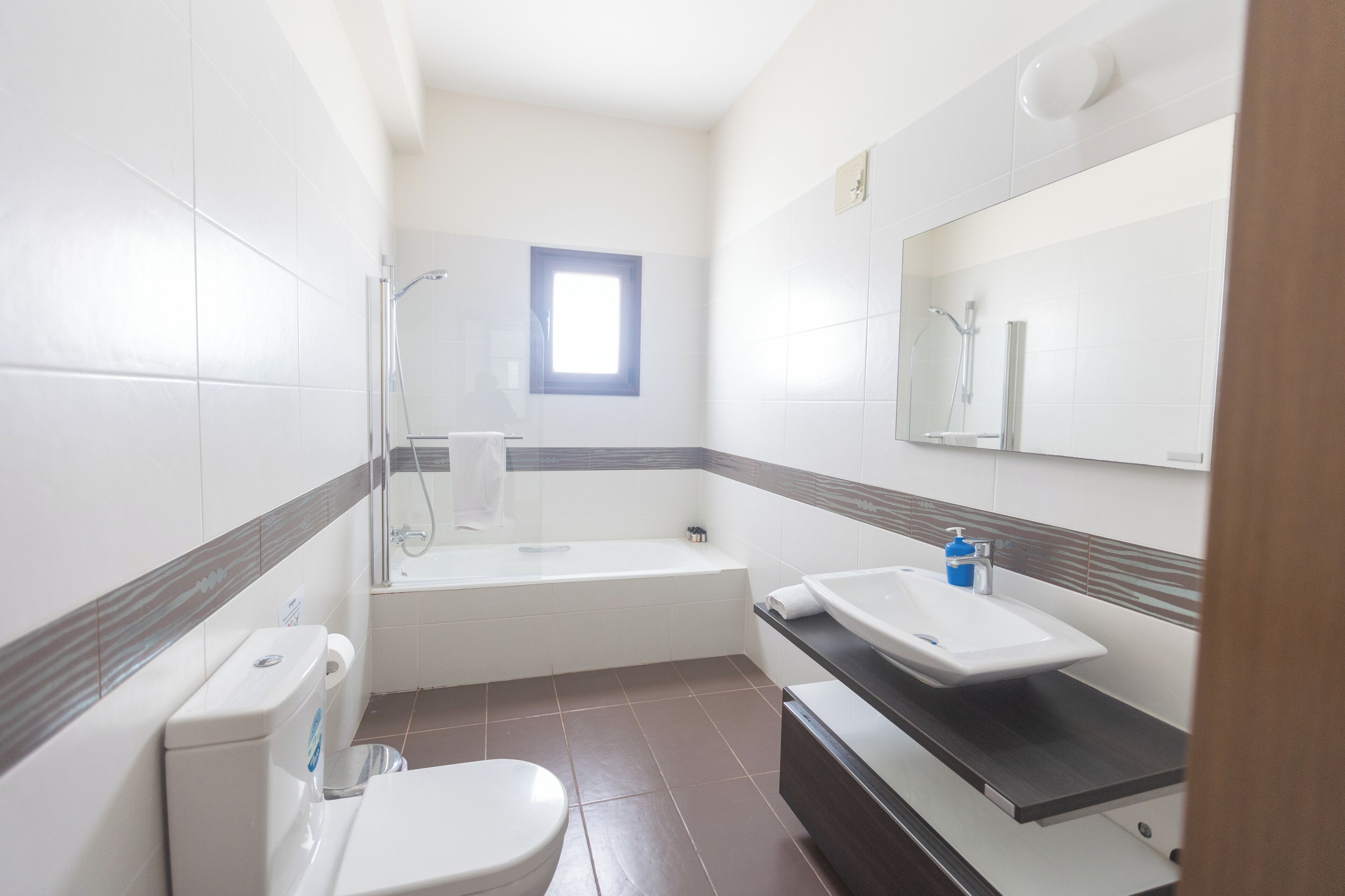 A modern bathroom with a toilet, sink, and bathtub.
