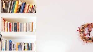 A neatly organized bedroom with a bookshelf, bedside table, and a bed. - the Cosy Modern and Comfortable Apartment in the Heart of Heraklion City Centre (Heraklion)