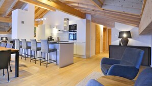 A modern interior with a kitchen, dining area, and seating. - Chalet in French Alps near Lake Geneva (Abondance)