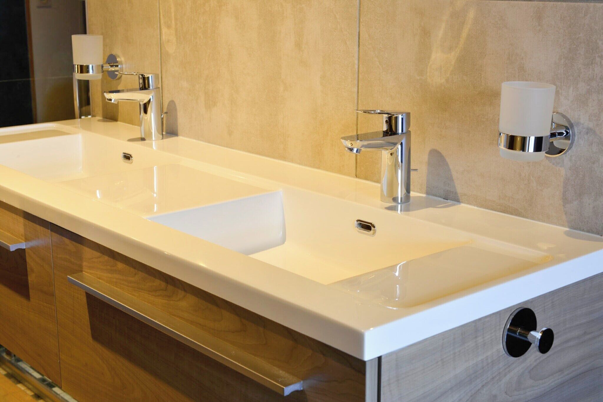 A modern bathroom with a double sink, chrome fixtures, and a towel rack.