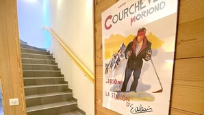 Un escalier en bois orné d’une affiche publicitaire pour la station de ski de Courchevel Montorond.