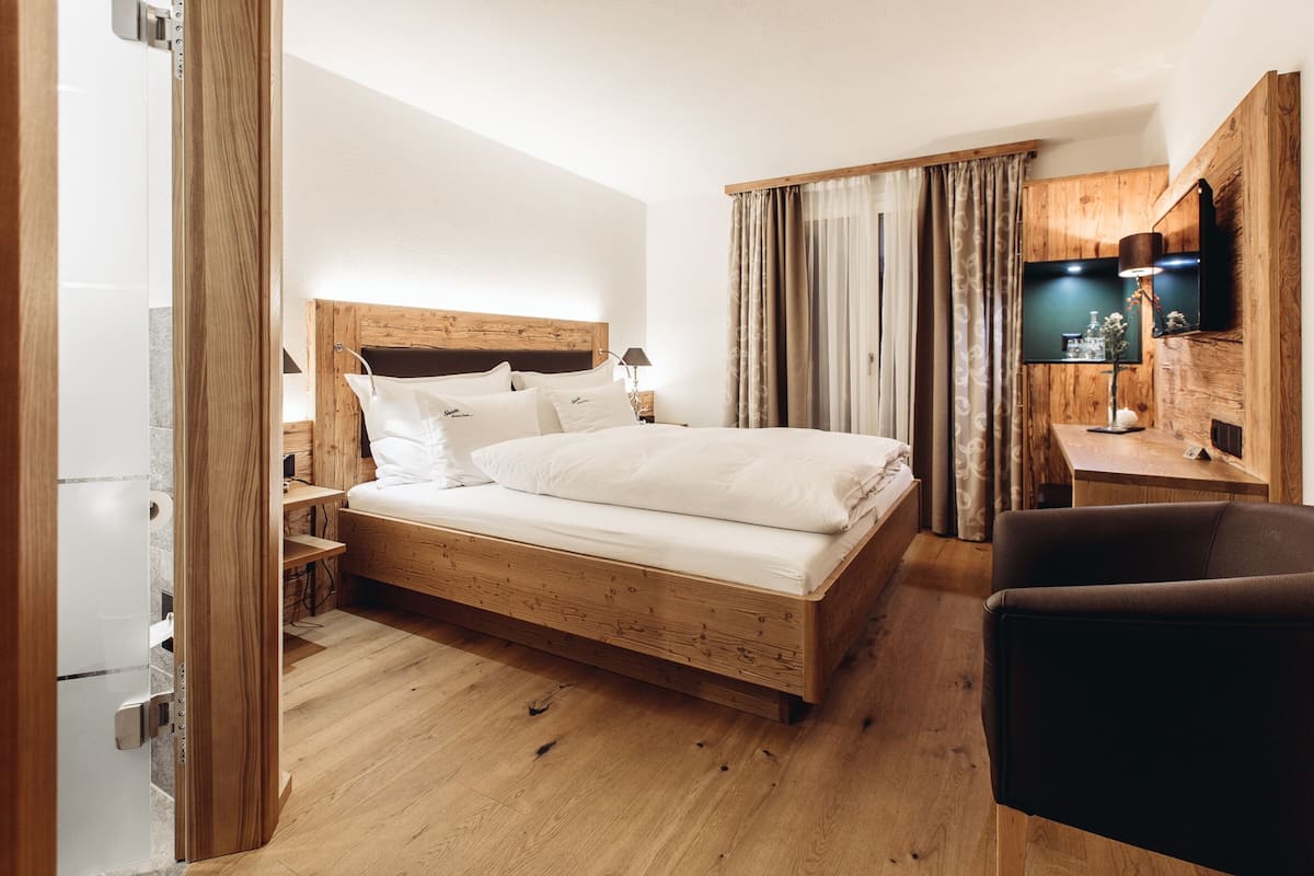 Une chambre moderne avec un lit en bois, un bureau et un téléviseur.