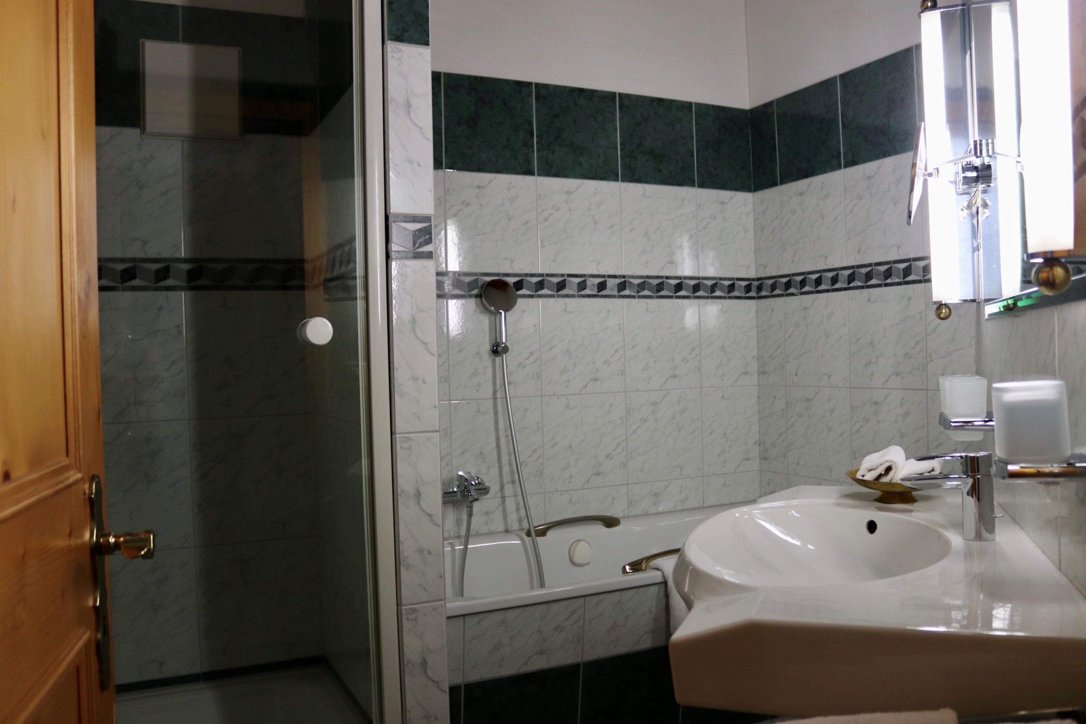 Une salle de bain avec une douche à parois de verre, un lavabo blanc et un miroir.