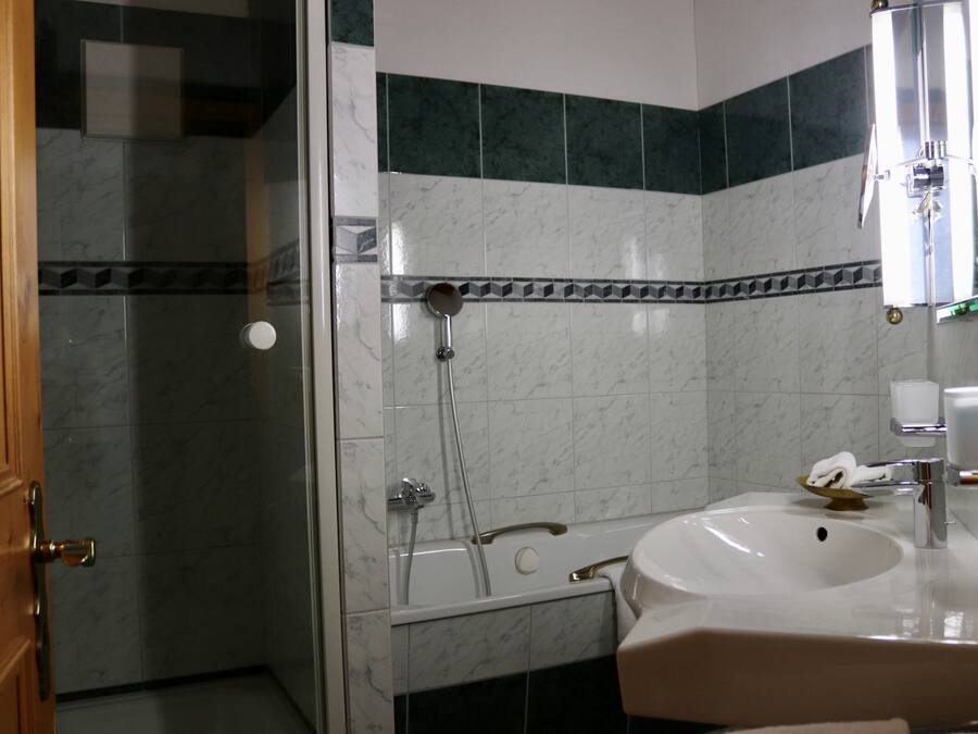 Une salle de bain avec une douche à parois de verre, un lavabo blanc et un miroir.