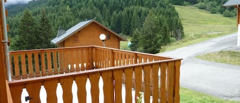 Ein Holzbalkon mit Blick auf einen bewaldeten Berg.