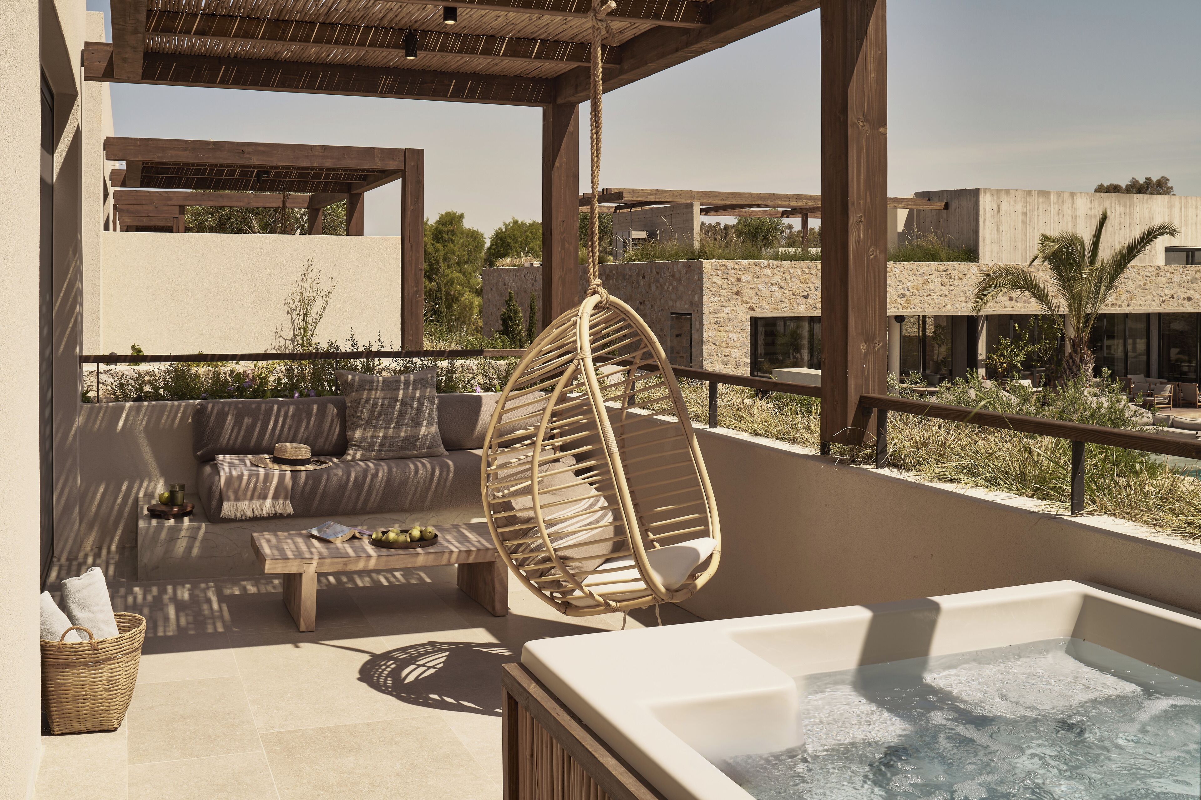 Une terrasse sur le toit équipée d’un jacuzzi, d’un fauteuil suspendu, d’un canapé et d’une table basse.