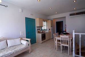 A compact living space with a kitchenette, a dining area, and a seating area with a sofa.