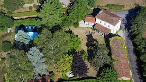 An aerial view of a property with a swimming pool, a large white building with a tiled roof, and surrounding greenery. - bed & Breakfast (Sonnac)