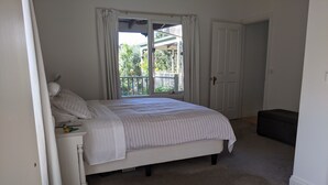Ein Schlafzimmer mit einem Bett, einer Bank, einer Tür und einem Fenster.