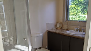 Ein Badezimmer mit Toilette, Waschbecken und einem Fenster.