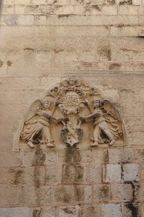 A detailed stone carving of two angels on a wall. - Anima Mea Old Town Apartment (Dubrovnik)
