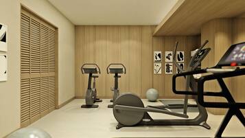 Academia moderna com bicicletas ergométricas, esteira e bolas de exercício.