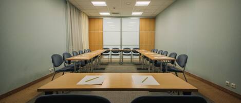 A conference room with a long table, chairs, and a whiteboard.