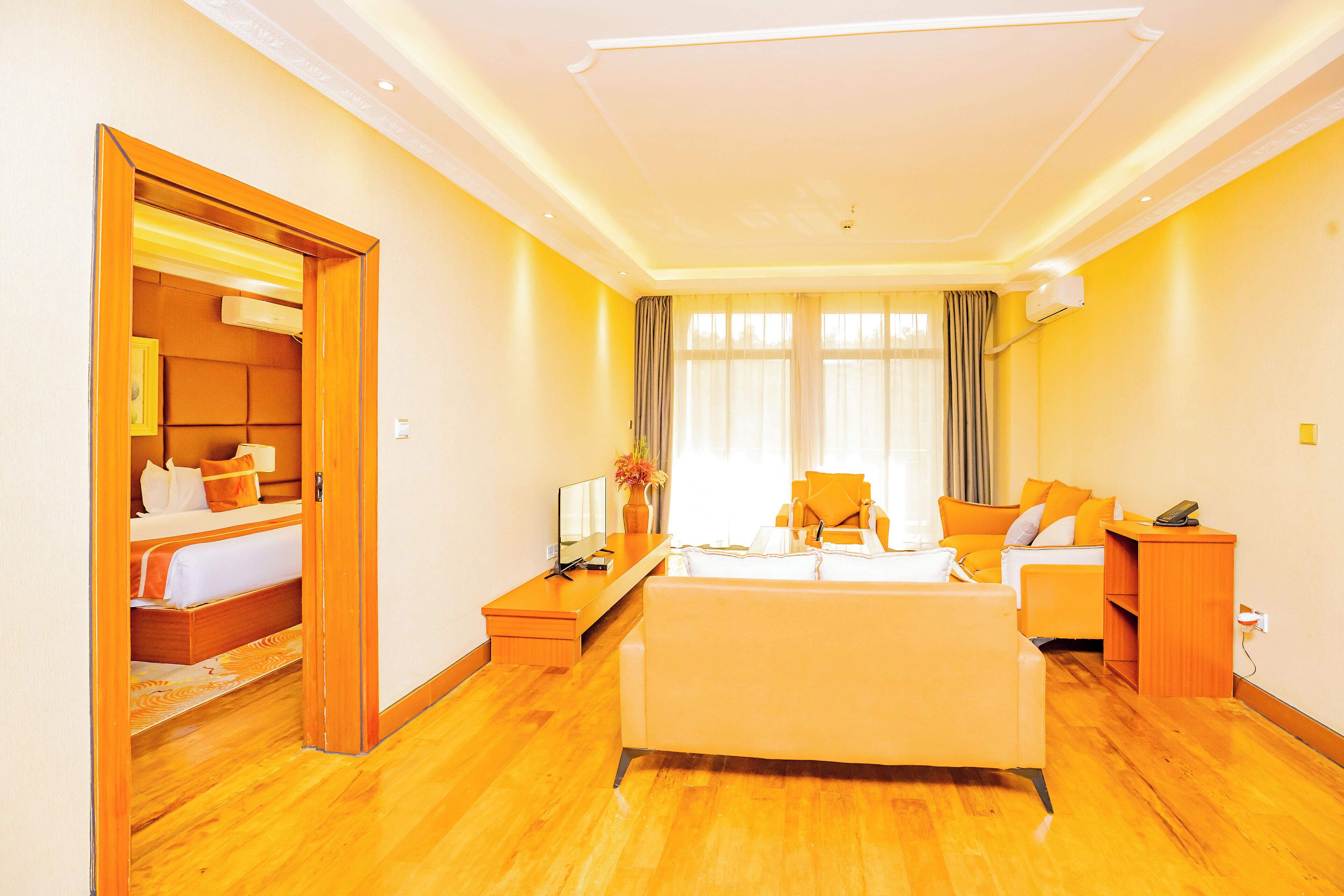 Ein Hotelzimmer mit Bett, Sofa, Schreibtisch und Fernseher.