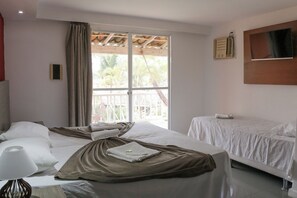A hotel room with two beds, a large window with a view of palm trees, a ceiling fan, and a mounted TV.